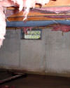 Iowa crawl space with vents, showing mold, rot, and fiberglass insulation dripping off the ceiling.