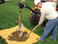 Auguring a hole in the earth for a foundation wall repair system in Fort Dodge